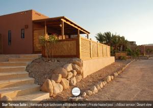 Uma casa com um monte de pedras à volta. em Zman Arava em Zuqim