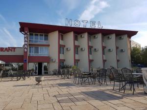 un hôtel avec des tables et des chaises devant lui dans l'établissement Hotel Caras, à Oraviţa