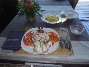 a table with a plate of seafood and a glass of wine at Boraha Village Ecolodge in Ambodifototra +52 photos