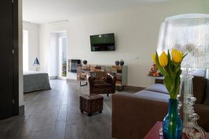 uma sala de estar com um sofá e uma mesa com flores amarelas em Relais Al Porto em Peschiera del Garda