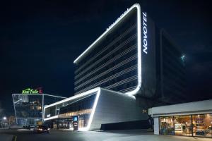 a large building with a sign on it at night at Novotel Almaty City Center in Almaty
