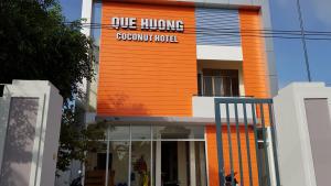 un bâtiment avec un panneau d'hôtel à croissance suspendue dans l'établissement Que Huong Coconut Hotel, à Giồng Tú Ðiền