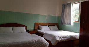 Een bed of bedden in een kamer bij Que Huong Coconut Hotel