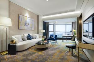 a living room with a white couch and a table at Grand Millennium Shanghai HongQiao in Shanghai