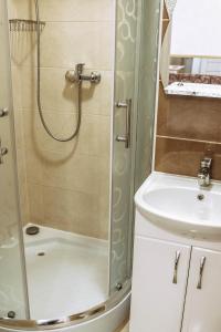 uma casa de banho com um chuveiro e um lavatório. em Hotel Rafinad em Lviv