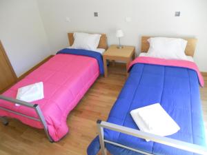 dos camas sentadas una al lado de la otra en una habitación en Azores Youth Hostels - São Jorge, en Calheta