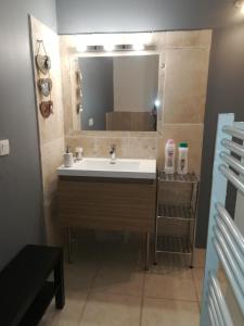 W łazience znajduje się umywalka i lustro. w obiekcie Au pays du Ventoux w mieście Le Thor