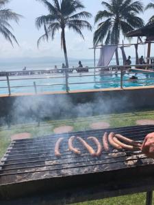 una parrilla con salchichas junto a una piscina en Sun Beach Bungalows, en Haad Rin