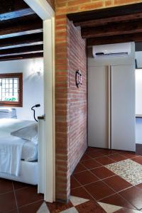 ein Schlafzimmer mit einem Bett und einer Ziegelwand in der Unterkunft Antico Caminetto alla Biennale in Venedig