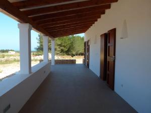 a corridor of a house with a wooden ceiling at Casa S'Olibassa in La Mola