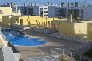 a view of a building with two pools and chairs at CasaDuarte "doMar" in Lagos