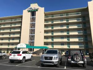 dois carros estacionados num parque de estacionamento em frente a um hotel em The River Cottage em Pigeon Forge