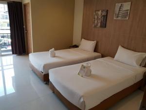 a hotel room with two beds and a window at OMG Hotel in Khon Kaen