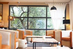 a living room with chairs and a large window at Domaine du Ferret Restaurant & Spa in Cap-Ferret