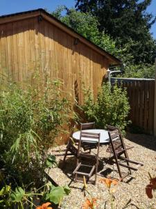 een tafel en stoelen in een tuin met een hek bij gîte papillon 4 in Civray-de-Touraine