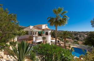 una casa con una palmera y una piscina en Villa Ritter - three bedroom with private pool - by Holiday Rentals Villamar, en Benissa