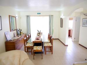 comedor con mesa, sillas y escritorio en Azure Villa, en Belle Mare