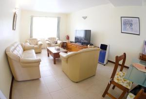 sala de estar con sofás y TV de pantalla plana. en Azure Villa, en Belle Mare