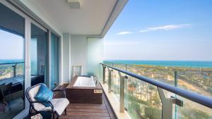 a balcony with a tub and a view of the ocean at Neal Yat Seaview Apartment Haitang Bay Sanya in Sanya