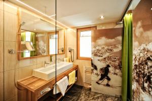 a bathroom with a sink, toilet, and bathtub at Hotel Arnika in Ischgl