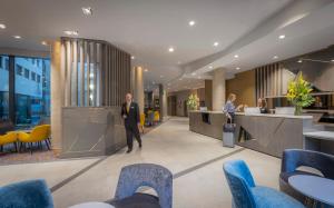 a man in a suit walking through a lobby at Maldron Hotel Newcastle in Newcastle upon Tyne