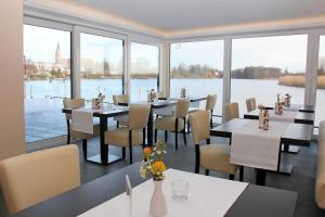ブランデンブルク・アン・デア・ハーフェルにあるFerienwohnung am Pfaffe-Kaiの水辺の景色を望むテーブルと椅子付きのレストラン