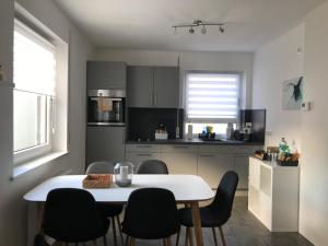 a kitchen with a white table and chairs in a room at Apartment Friedrichshafen Center in Friedrichshafen