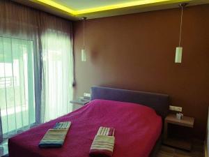 sypialnia z różowym łóżkiem i 2 ręcznikami w obiekcie Luxury Apartments Near to the beach w mieście Plakias