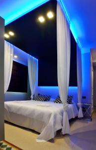 a bedroom with a bed with white curtains at Villa La Fenice in Reggio Calabria