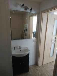 WaksmundApartament Miodowy Waksmund-NowyTarg的浴室里有洗手池和镜子 更多22张照片