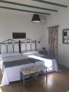 Un dormitorio con 2 camas y un banco. en Mesón de Sancho en Tarifa