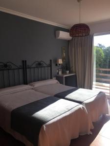 ein Schlafzimmer mit einem großen Bett und einem großen Fenster in der Unterkunft Mesón de Sancho in Tarifa