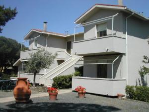 una casa blanca con macetas de flores delante de ella en Affittacamere FloraMare, en Marina di Bibbona