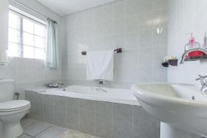 La salle de bains est pourvue de toilettes, d'une baignoire et d'un lavabo. dans l'établissement Kingfisher Hollow, à Gordons Bay