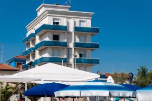 a tall building with umbrellas in front of it at Hotel Sayonara in Senigallia
