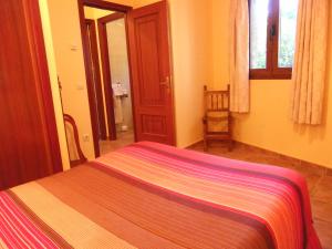 Un dormitorio con una cama con una manta de colores. en Casa Rural El Corralico, en Ribadelago