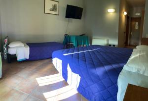 a bedroom with two beds and a flat screen tv at Hotel Riviera Ristorante La Briciola in San Bernardino
