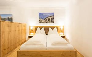 Schlafzimmer mit einem großen weißen Bett und Holzschränken in der Unterkunft Altes Backhaus in Eisenstadt