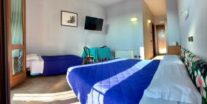 a bedroom with two beds and a tv in it at Hotel Riviera Ristorante La Briciola in San Bernardino