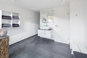 诺德奈Storchennest Norderney的带水槽和镜子的白色浴室 更多46张照片