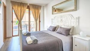 Apartment Peninsula في ليجيان: غرفة نوم بها سرير كبير مع مناشف عليه