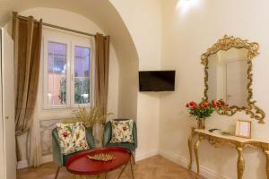 Habitación con espejo, silla y mesa. en Ingrami Suites and Spa en Roma