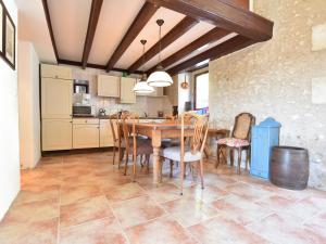 uma cozinha e sala de jantar com mesa e cadeiras em Beautiful holiday home with private pool em Lusignac