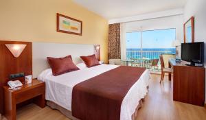 a hotel room with a large bed and a television at CM Castell de Mar in Cala Millor