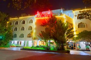 a large white building with red lights on it at Maya's Kings Kourt in Mysore