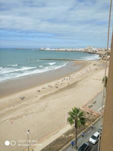 a view of a beach with people and the ocean at GUESTING VELAZQUEZ in Cádiz