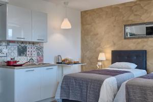 a bedroom with two beds and a kitchen with a counter at Luxury flats in city centre in Pula