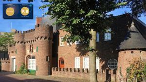 a large red brick castle with a tree in front of it at Casa Mia Sittard in Sittard