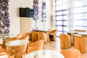 ein Restaurant mit Tischen und Stühlen sowie einem TV in der Unterkunft Hotel ibis Evora in Évora