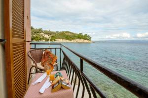 a table on a balcony with a view of the ocean at Mermaid cottage in Longos